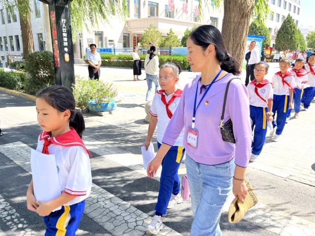 02 臨澤縣城關(guān)小學(xué)“紅燭先鋒”護(hù)學(xué)崗教師護(hù)送學(xué)生放學(xué)。謝靜 攝.jpg